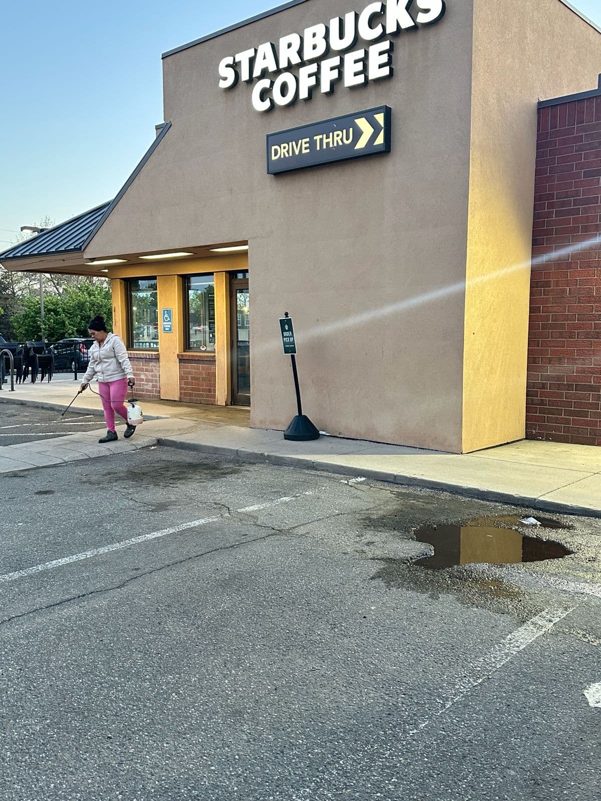 Kathy Clean technician cleaning the sidewalk at a Starbucks drive-thru location in Denver