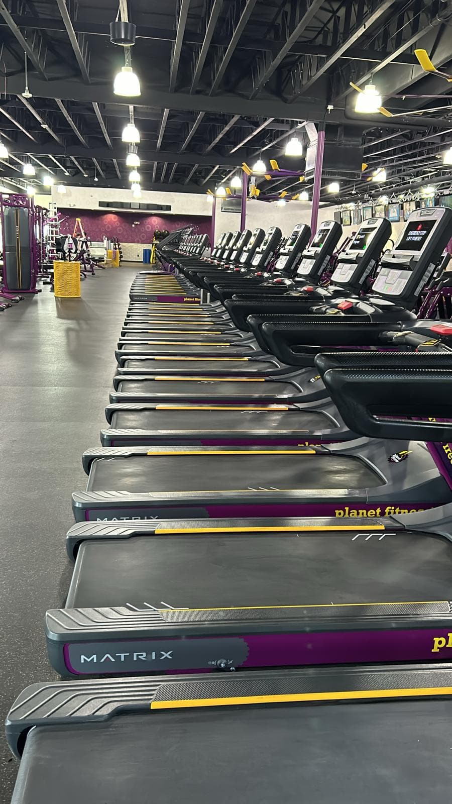 Clean row of Matrix treadmills at a Planet Fitness gym in Denver