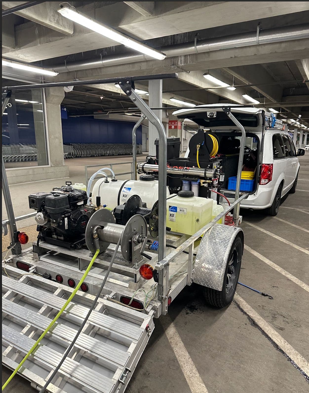 Kathy Clean professional equipment trailer with pressure washer and hose reel parked at a commercial facility in Denver