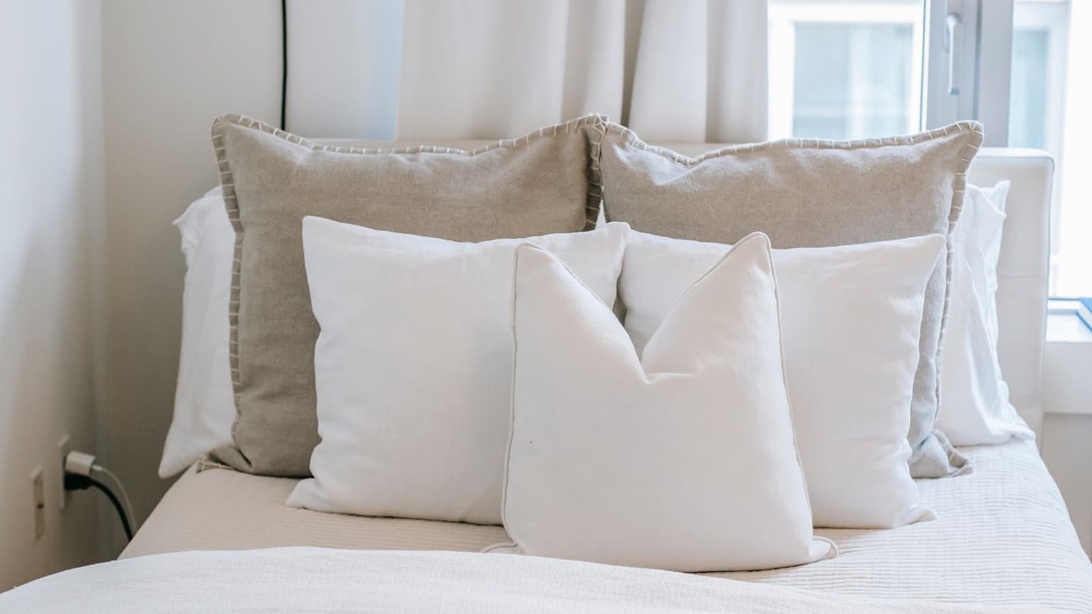 Clean, fresh bedroom with light linens and natural light