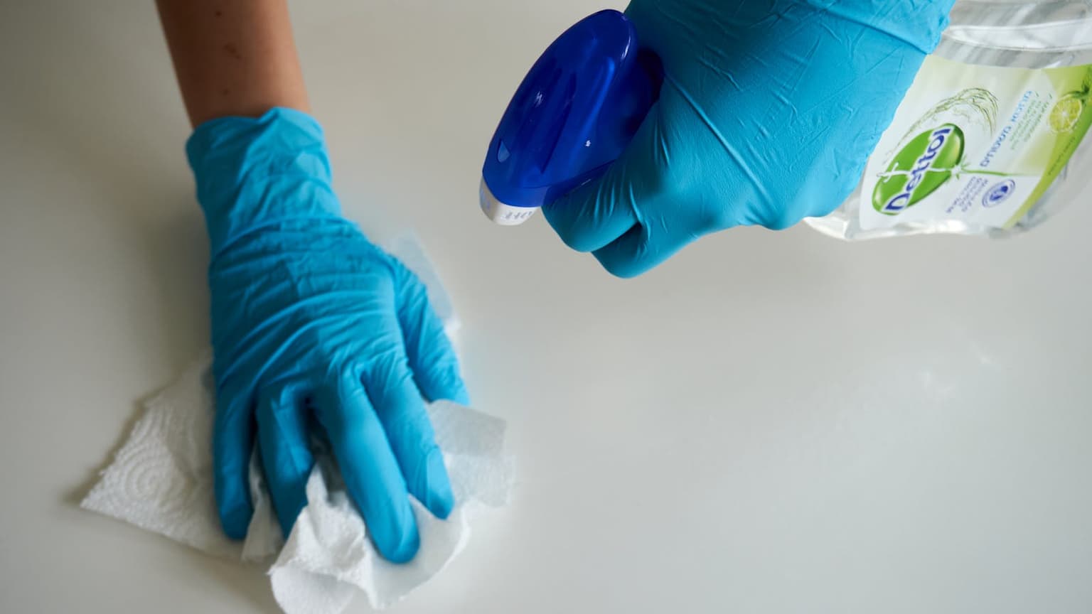 Cleaning professional wiping a surface with gloves